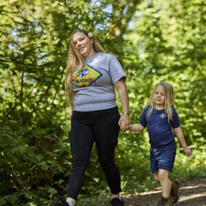 Mom and daughter wearing cub scout activity shirts enjoying a walk together on a fun scouting activity.