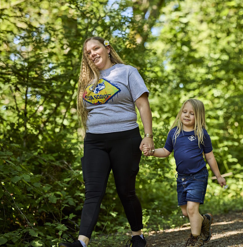 Mom and daughter wearing cub scout activity shirts enjoying a walk together on a fun scouting activity.